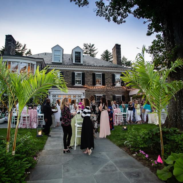 Guests walking a garden path toward a house at dusk